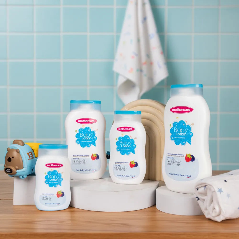 Mothercare Baby Lotion French Berries Collection From Small to Family Sizes placed on a platform with kids toys and clothing in a kids bathroom