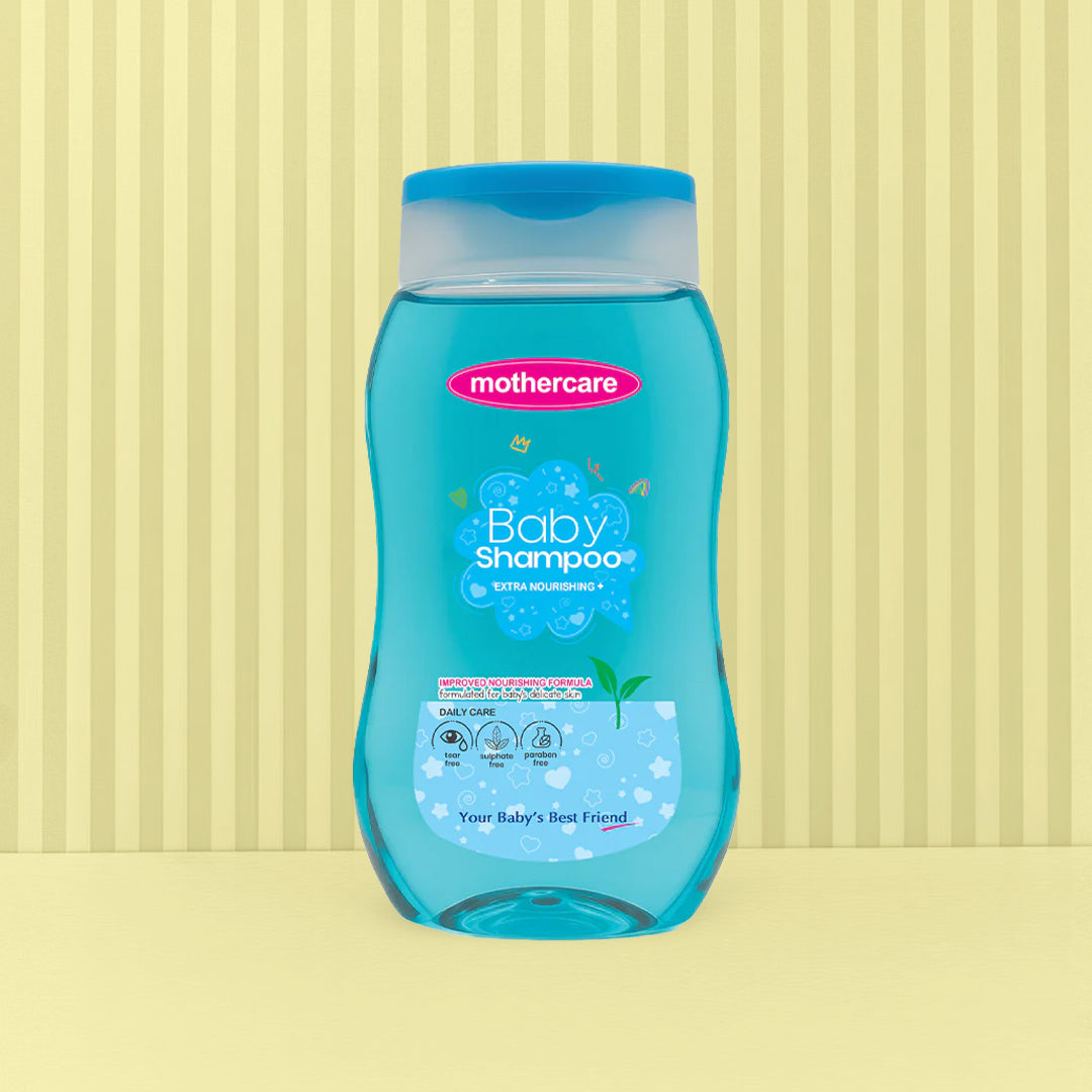 A bottle of Mothercare Baby Shampoo Blue Extra Nourishing with blue liquid and a blue cap, centered against a light yellow background with vertical stripes.